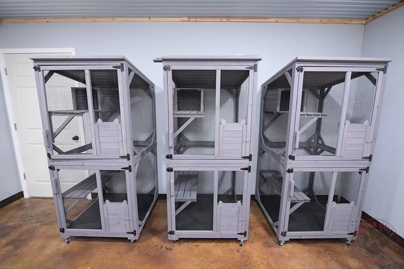 Three two-story wooden Cat Condos with mesh fronts, climbing levels, and hideaway dens